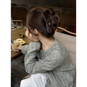 Elegant dark brown plush heart claw clip for women worn in a stylish autumn cafe setting