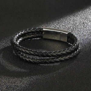Close-up of double-layer black leather woven bracelet with silver magnetic metal clasp