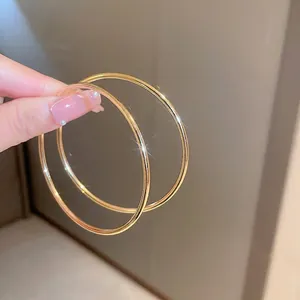 Minimalist large gold metal hoop earrings with a polished finish for a classic look