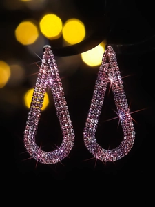 Macro shot of rose pink crystal droplet earrings with sparkling tassel details