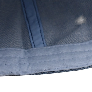 Dettaglio ravvicinato delle cuciture interne e della trama del tessuto denim del cappello