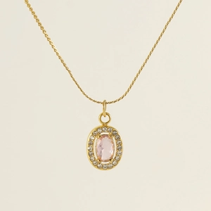 Close-up of golden oval pendant necklace with pink gemstone and rope chain detail