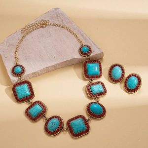 Bohemian jewelry set with turquoise stones and red rhinestones on a textured stone