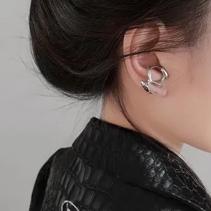 Dettaglio di un ear cuff in metallo liquido argento con design organico irregolare su modella