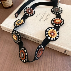 Detail of vintage bohemian leather waist belt with floral star studs and silver rivets