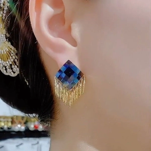 Detail of s925 silver fringe earrings featuring blue checkered studs and gold tassels