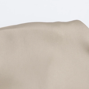 Macro-opname van beige satijnen stof met elegante zijdeachtige textuur en gladde afwerking