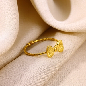 Detail of 18K gold-plated bow ring featuring twisted rope band and textured finish
