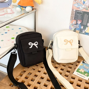 Sweet canvas crossbody bags in black and beige featuring stylish bow embroidery detail