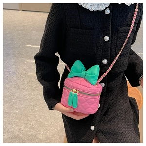 Pink quilted leather girl's crossbody bag with large green bow and gold chain strap