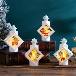 White Christmas lanterns with Santa and reindeer motifs on vintage books and wood base