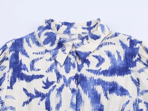 Detail shot of blue and white floral shirt dress collar with white buttons and soft pleats