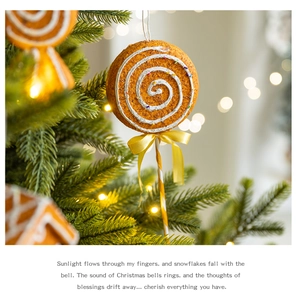Macro view of gingerbread lollipop ornament with white spiral patterns and yellow bow