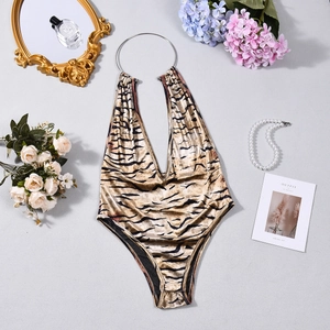 Macro shot of tiger print bodysuit with deep V-neckline and metallic ring strap details