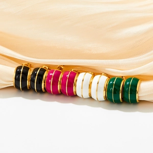 Vintage geometric enamel earrings in colorful stripes on silk fabric backdrop