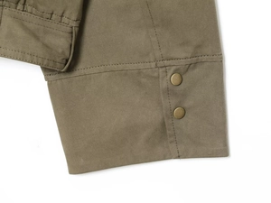 Close-up of olive green cotton twill cuff with two bronze metal snap buttons