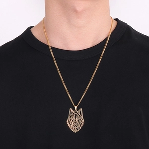 Détail d'un pendentif tête de loup évidé doré avec une chaîne cubaine porté par un mannequin