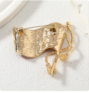 Detail view of the golden flag brooch back with tassel decoration and secure clasp mechanism
