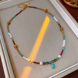 Detailed view of turquoise and pearl necklace with colorful beads on a jewelry tray