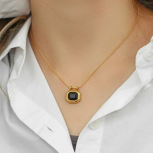 Detail of 18K gold plated necklace with square black zircon pendant on a snake chain