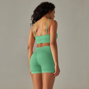 Detail of mint green seamless yoga set showing cross back sports bra and high waist shorts