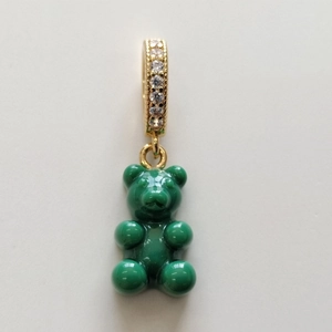 Close-up of green gummy bear resin pendant with gold rhinestone clasp on white background