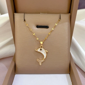 Macro detail of a dolphin pendant with white shell inlay and gems in a jewelry box