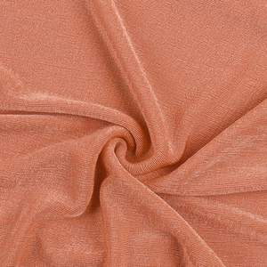 Detailed close-up of ruffle texture and orange knitted fabric with spiral pleats