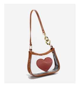 Detailed view of clear PVC crossbody bag with brown trim and red heart logo accent