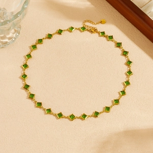 Close-up of gold-plated stainless steel necklace with green square emerald-cut crystals