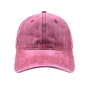 Close-up of washed burgundy cotton fabric texture and stitching on a vintage baseball cap
