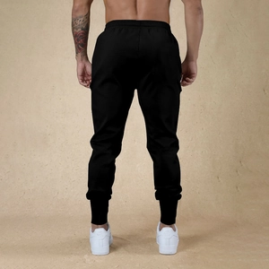 Vista trasera de joggers negros ajustados para hombre que resalta el corte y la tela