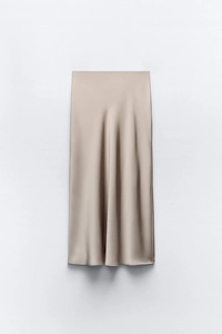 Detailansicht des champagnerfarbenen Satin-Midirocks mit seidiger Textur und Faltenwurf