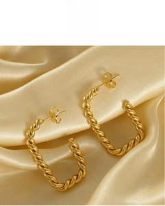Vue détaillée des boucles d'oreilles créoles carrées torsadées plaquées or 18 carats sur satin