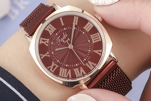 Close-up of square rose gold watch with burgundy sunray dial and Roman numerals
