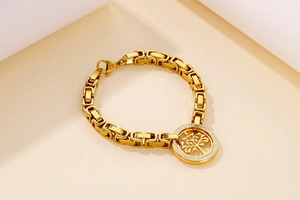 Macro detail of gold-plated Tree of Life charm bracelet with sparkling zirconia stones