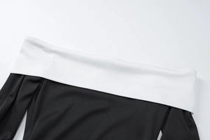 Détail de l'encolure de la robe en maille bicolore à épaules dénudées avec une texture douce