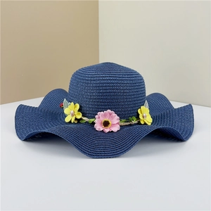 Detail of navy woven straw hat with wave brim and colorful floral decoration