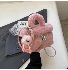 Pink faux shearling crossbody bag with fuzzy charm and detachable strap detail