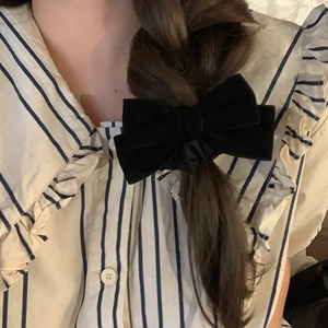 Elegant black velvet bow hair tie accessory on model for vintage French style