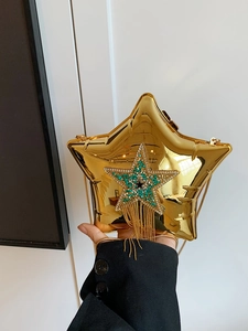 Detail of star shaped bag with green rhinestone tassels and a golden chain strap