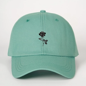 Detail of mint green baseball cap featuring black rose floral print on the center front
