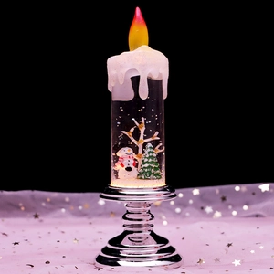 Macro shot of Christmas lantern showing glowing snowman and tree in glittering liquid