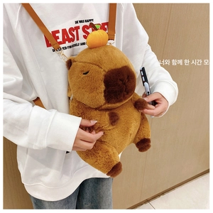 Detail of plush Capybara backpack with a mini orange on head shown on model