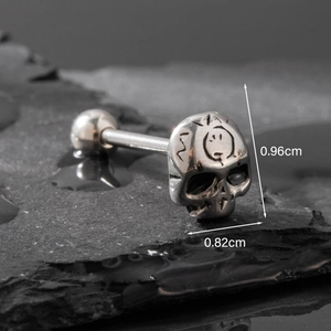 Silver skull tongue ring in stainless steel with 0.96cm height on dark stone base