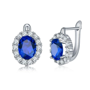 Detailed view of silver leverback earrings with blue oval sapphire and zircon halo