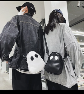 Rear view of models wearing cute ghost-shaped PU crossbody bags in black and white colors