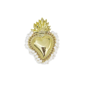 Macro view of handmade gold Sacred Heart pendant with white bead border detail