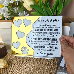 Close-up of heart and footprint cutouts on an acrylic Mother's Day plaque