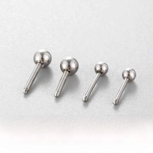 Makroaufnahme von silbernen Titanstahl-Piercing-Steckern mit Schraubkugel und Gewinde
